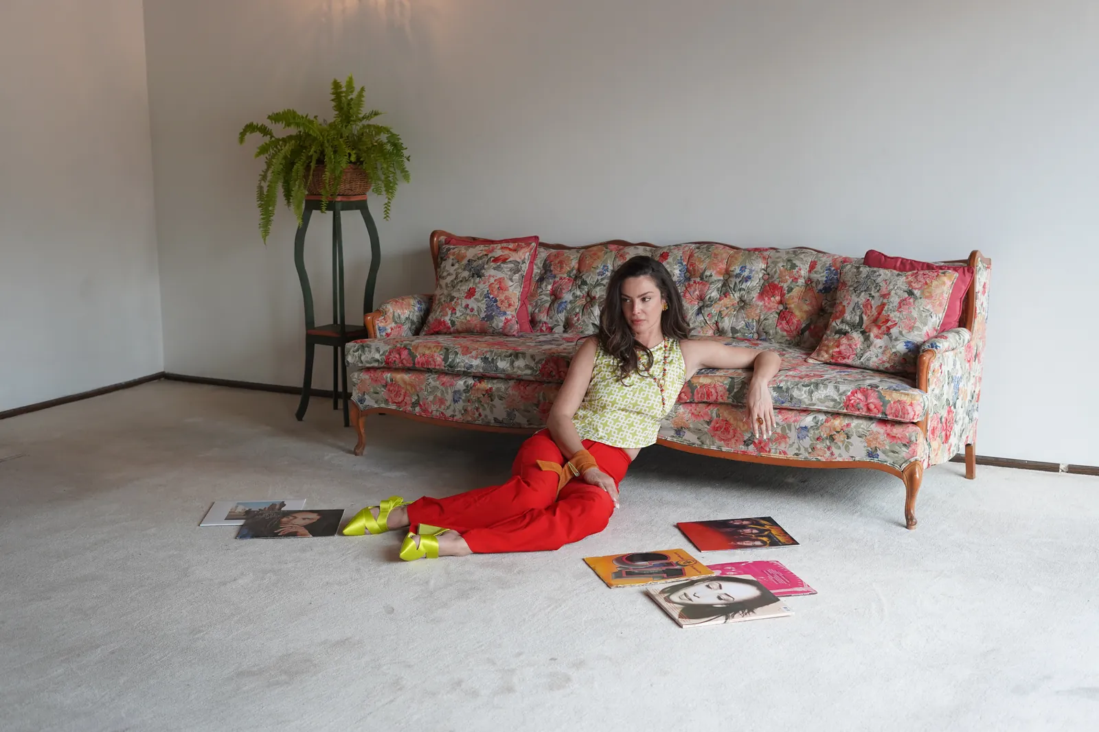 Editorial · Plano abierto de set Fotografía de moda y lifestyle editorial en CDMX: modelo posando en set con sofá floral y vinilos — Sistema Creativo